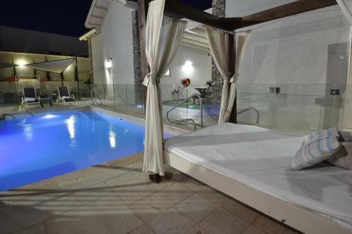 a bedroom with a bed and a swimming pool at הקצה- The Edge in Sifsufa