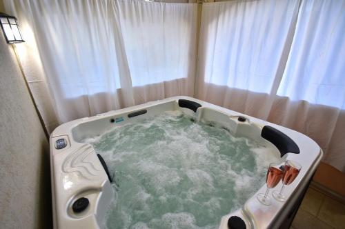 a bath tub filled with water in front of a window at הקצה- The Edge in Sifsufa