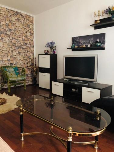 a living room with a tv and a glass coffee table at WLD House in Constanţa