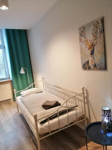 a bedroom with a bed and a painting on the wall at Apartament Galicja Plus in Chrzanów