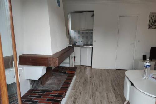 una piccola cucina con armadietti bianchi e pavimento in mattoni di Super Appart entre Paris et Dysney équipé(Ref: KA) a Montfermeil