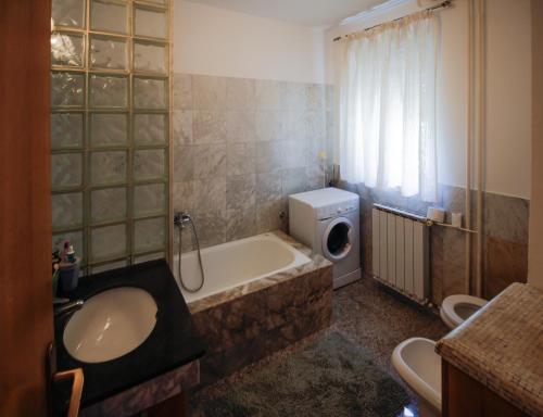 uma casa de banho com uma banheira, um lavatório e um WC. em Apartment Šverko em Kastav