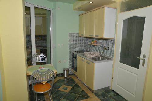 a small kitchen with a table and a sink at Rooms and Apartaments De Niro in Trpejca