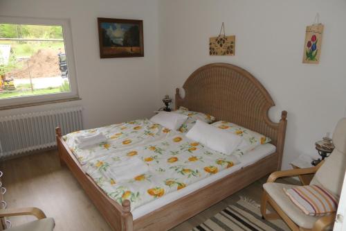 a bedroom with a bed and a chair and a window at Apartments and rooms Brunko in Bled