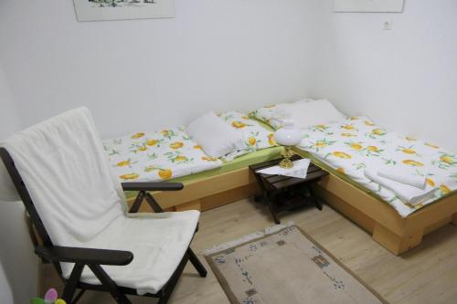 a bed and a chair in a room at Apartments and rooms Brunko in Bled