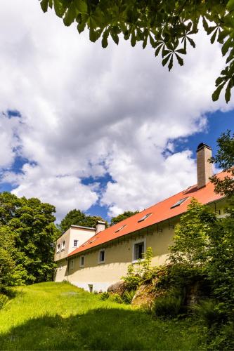a building with an orange roof on a hill at Penzion Kozí farma Nový Dvůr in Česká Lípa