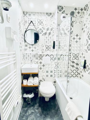 a bathroom with a toilet and a tub and a sink at Sure Hotel by Best Western Calais Coquelles Tunnel s/ Manche in Coquelles