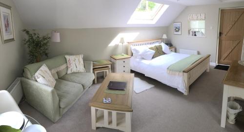 een kleine slaapkamer met een bed en een bank bij Frogmill Studio in Exeter