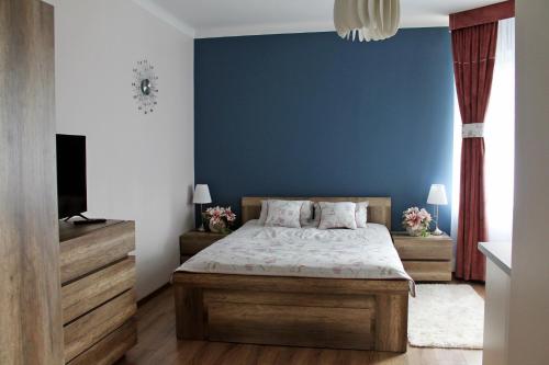 een slaapkamer met een bed en een blauwe muur bij Apartamenty w Kamienicy in Poddębice