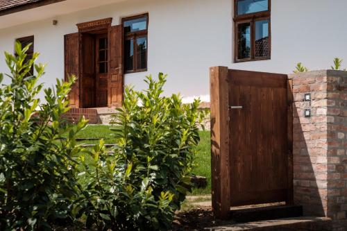 an open wooden door in front of a house at Almalomb Apartman in Hosszúhétény