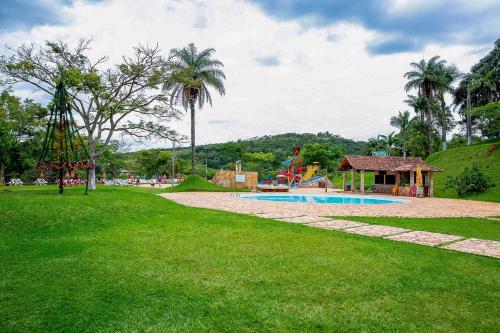 a park with a swimming pool and a playground at Hotel Rio de Pedras in Itabirito