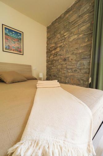 a bed in a room with a stone wall at Rivacanze Apartments in Laglio