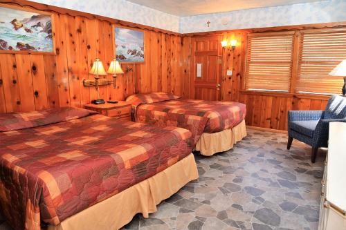 a hotel room with two beds and a chair at The Kern Lodge in Kernville