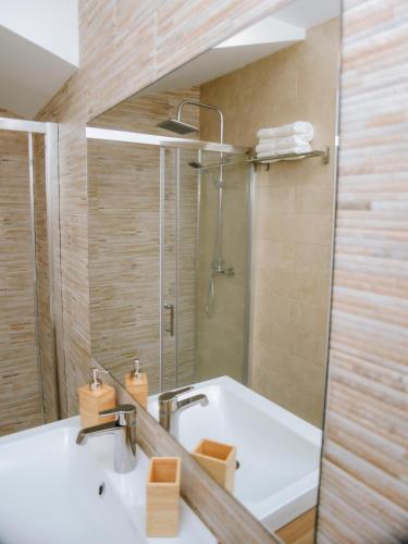 a bathroom with a sink and a shower at ERES EMÉRITA "Apartamentos & Suites" in Merida