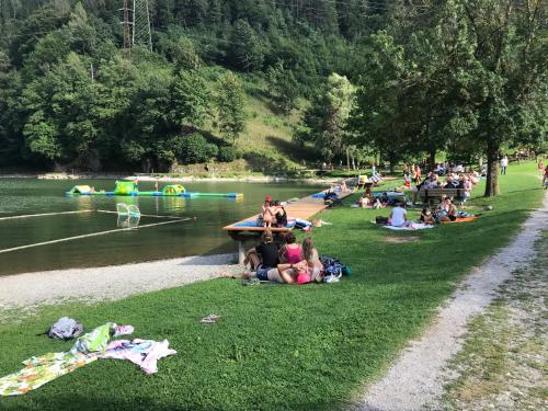 a group of people sitting on the grass near a river at Suite Romantica Fuga in Roncone