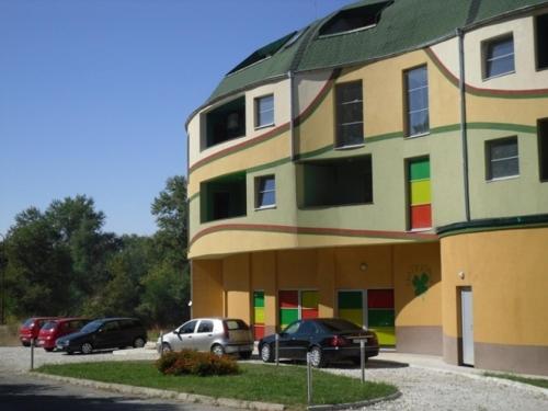 un edificio multicolor con coches estacionados frente a él en Detelina Complex, en Hisarya