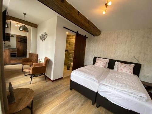 a bedroom with a bed and a living room at Hotel Crasborn Thorn in Thorn
