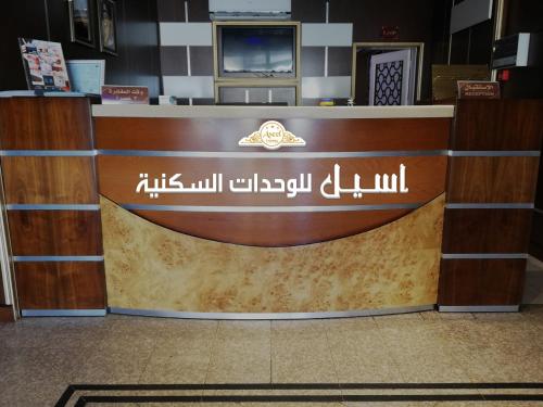 a counter in a store with a sign on it at Aseel Furnished Apartments in Jeddah