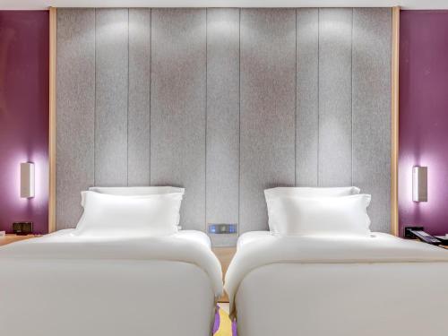 A bed or beds in a room at Lavande Hotel Tianjin Joy City Gulou Subway Station