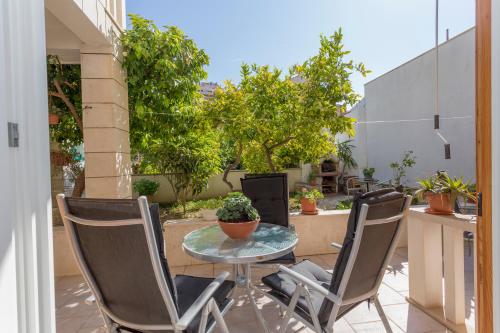 a patio with a table and chairs and plants at Historic center Hvar town- a few steps from the main square in Hvar