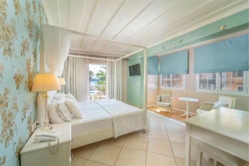 een slaapkamer met een bed, een raam en een tafel bij Orion Hotel in Nydri