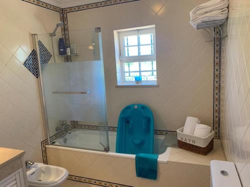 a bathroom with a tub and a toilet and a sink at Casa das Roseiras in Ferragudo