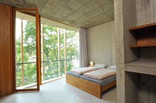 a bedroom with a bed and a large window at Basel Youth Hostel in Basel