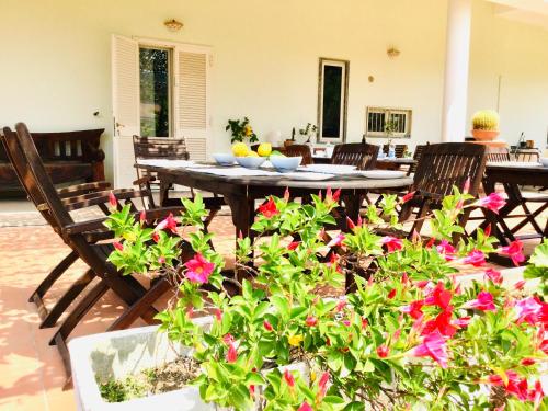 a patio with a table and chairs and flowers at Villa Liberti in Castellabate