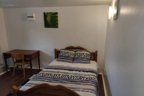 une petite chambre avec un lit et une table dans l'établissement Super Appart ds pavillon, équipé, calme (Ref: KA0), à Montfermeil