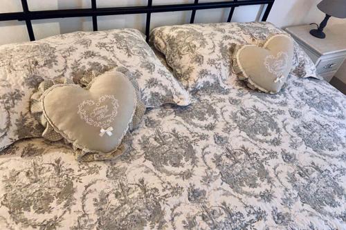 a bed with two pillows with hearts on it at La Casetta di nonnaNà - Casa vacanze in Terni