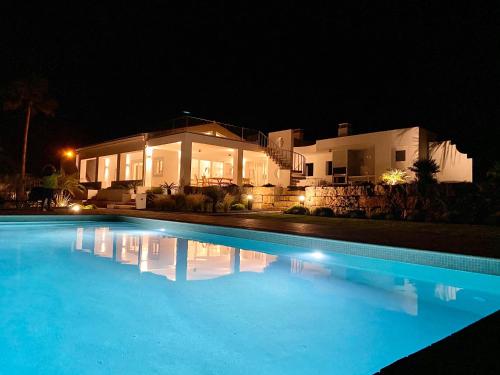 een zwembad voor een huis 's nachts bij Luxury Villa, Ocean View, Private Heated Pool in Ferragudo