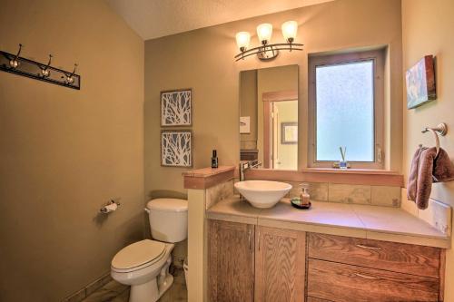 a bathroom with a toilet and a sink and a mirror at Luxe Coastal Haven with Bay Views and Hot Tub in Bay City