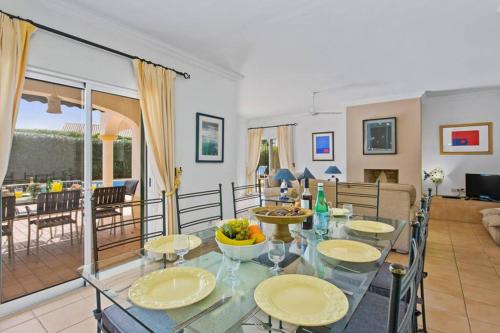 ein Esszimmer und ein Wohnzimmer mit einem Glastisch in der Unterkunft Villa White Sands - Private Oasis, Heated Pool, Beaches & Strip Nearby in Albufeira