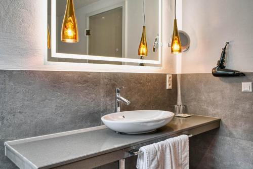 a bathroom with a sink and a mirror at Hotel Lipmann "Am Klosterberg" in Beilstein