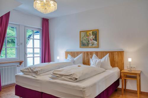 a bedroom with a large white bed with purple curtains at Hotel Lipmann "Am Klosterberg" in Beilstein