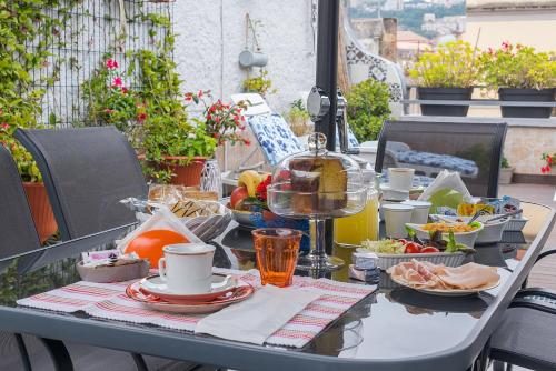 een tafel met eten en drinken op een balkon bij La Terrazza ai Miracoli in Napels