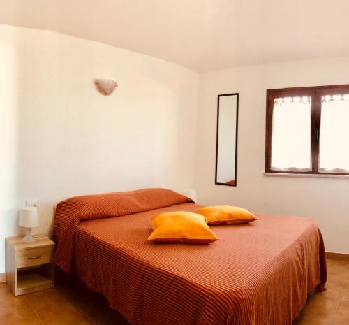 Un dormitorio con una cama con dos almohadas amarillas. en Siniscola Casa vacanze Olmo, en Siniscola
