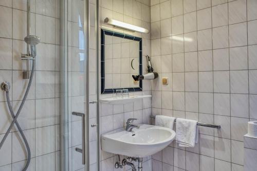 a white bathroom with a sink and a shower at Altes Zollhaus in Beilstein
