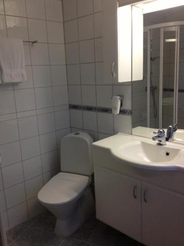 a white bathroom with a toilet and a sink at Hotel Svartisen in Mo i Rana