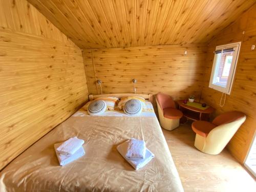 1 dormitorio con 1 cama en una habitación de madera en Domki Letniskowe Ster, en Międzyzdroje