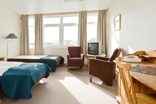 a hotel room with two beds and a television at Hotel Svartisen in Mo i Rana