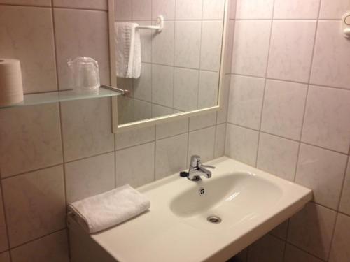Baño blanco con lavabo y espejo en Hotel Svartisen, en Mo i Rana