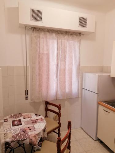 małą kuchnię ze stołem i lodówką w obiekcie Ortensia - Sanremo Apartments w San Remo