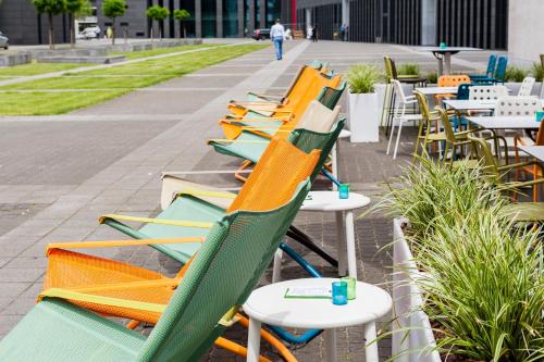 a row of colorful chairs and tables on a sidewalk at Holiday Inn Express Antwerpen City North by IHG in Antwerp