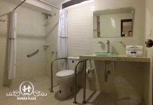y baño con aseo, lavabo y ducha. en Hotel Riviera Plaza, en Bucaramanga