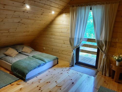 a bed in a room with a large window at GREEN HOUSE in Krasnopol