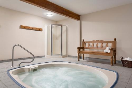a large bath tub in a room with a bench at Travelodge by Wyndham McBride in McBride