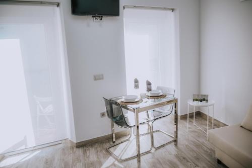 a white room with a table and a chair at ERES EMÉRITA "Apartamentos & Suites" in Merida