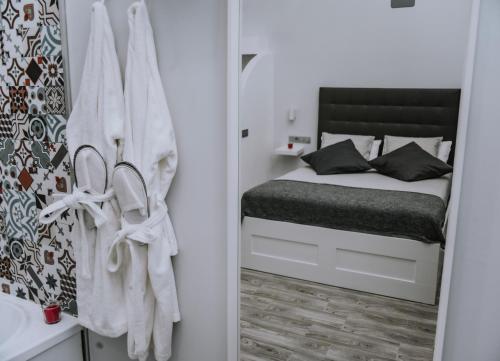 a bedroom with a bed with towels on the wall at ERES EMÉRITA "Apartamentos & Suites" in Merida