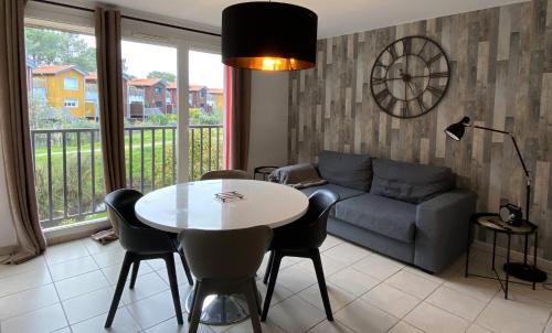 un salon avec une table et un canapé dans l'établissement Lénoka, à La Teste-de-Buch